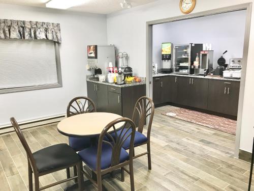 ein Esszimmer mit Tisch und Stühlen und eine Küche in der Unterkunft Baymont by Wyndham Marinette in Marinette