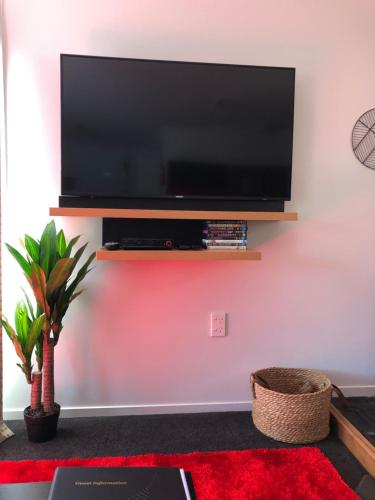 a living room with a flat screen tv on a wall at Hideaway - A Couples Retreat in Akaroa