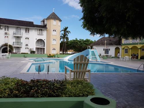 a swimming pool with a slide in front of a hotel at Almond Grove at Sand Castle in Ocho Rios