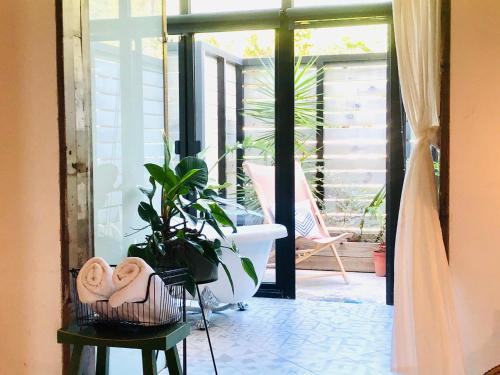ein Badezimmer mit einer Veranda mit einer Badewanne und einer Pflanze in der Unterkunft il Piccolo Polpo Hotel in Nanwan