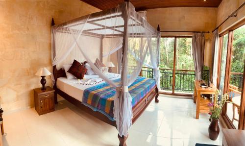 a bedroom with a canopy bed and a balcony at Sari House Ubud in Ubud