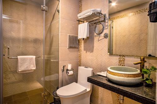 a bathroom with a toilet, sink, and shower stall at Arushi Boutique Hotel in Kathmandu