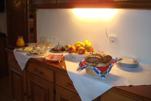 a table with a bowl of fruit and a plate of bread at Gästehaus Moser in Ramingstein