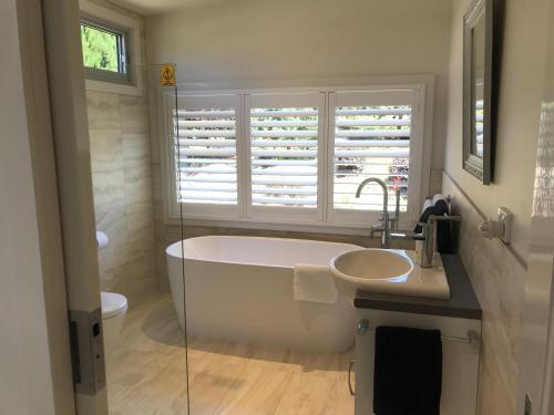 a bathroom with a tub and a sink and a window at SIGNAL BOX Short Stay in Gembrook