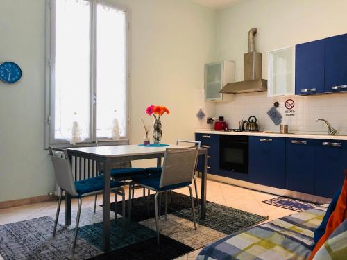 フィレンツェにある3 Perle all'Accademia Apartmentsのキッチン(テーブル、椅子、青いキャビネット付)