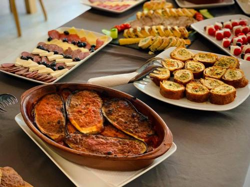 a table topped with plates of food and plates of snacks at Hotel Borea in Peje