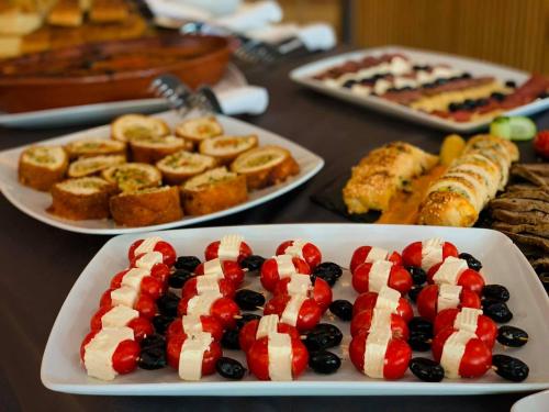 a table topped with plates of food with an american flagued food at Hotel Borea in Peje
