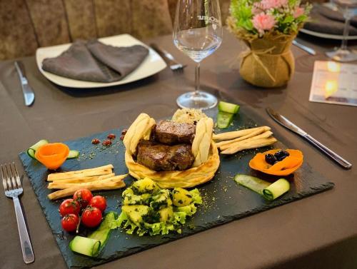 a plate of food with meat and vegetables on a table at Hotel Borea in Peje