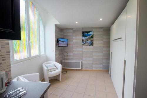 a living room with a chair and a window at Studio Mer , résidence Excelsior in Bagnères-de-Bigorre