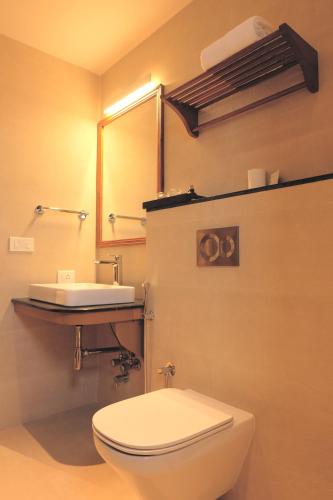 a bathroom with a white toilet and a sink at Rockholm at the Light House Beach in Kovalam