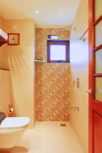 a bathroom with a toilet and a window at Rockholm at the Light House Beach in Kovalam