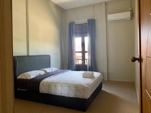 a small bedroom with a bed and a window at Sarah Guesthouse in Kuala Terengganu