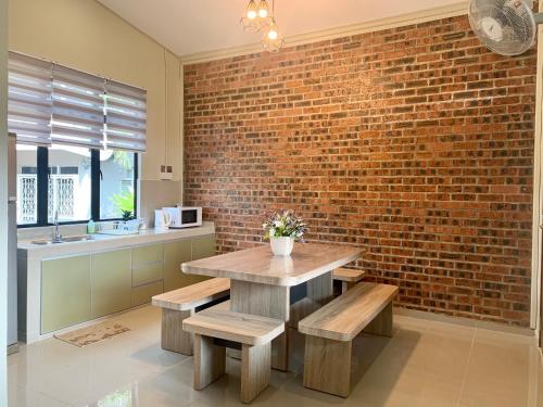 a kitchen with a brick wall and a table and benches at Sarah Guesthouse in Kuala Terengganu