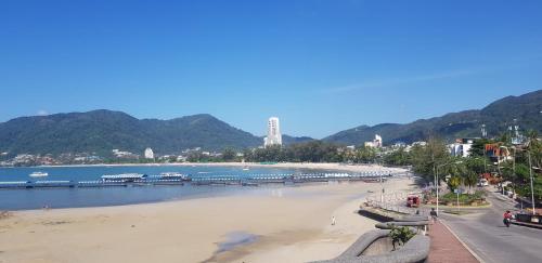 a view of a beach with mountains in the background at Sky Silk Decoration House in Patong Beach