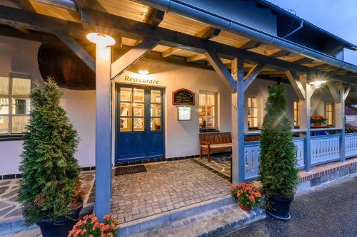 a restaurant with a blue door and a bench at MAXMILLIAN Pension & Restaurant in Mařenice