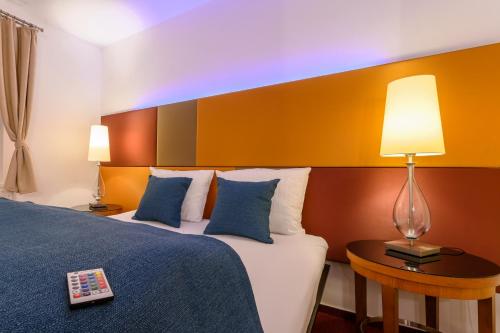a hotel room with a bed and a table with a lamp at MAXMILLIAN Pension & Restaurant in Mařenice