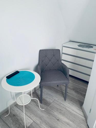 a chair and a table in a room at Parkowy Kudowa in Kudowa-Zdrój