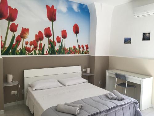 - une chambre avec un lit orné de tulipes rouges peints sur le mur dans l'établissement Cortile Cerami, à Catane