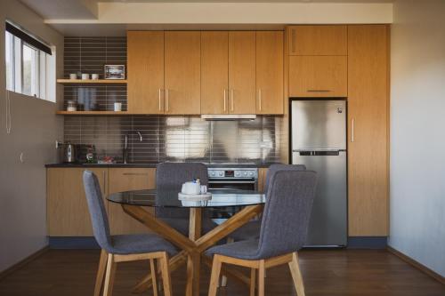 a kitchen with a table and two chairs and a refrigerator at Framtid Apartments and Holiday Homes in Djúpivogur