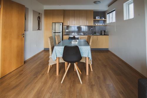 a kitchen with a table and chairs in a room at Framtid Apartments and Holiday Homes in Djúpivogur