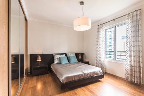 フンシャルにあるCosta Sol IX by Madeira Holiday Rentalsのベッドルーム1室(ベッド1台、大きな窓付)