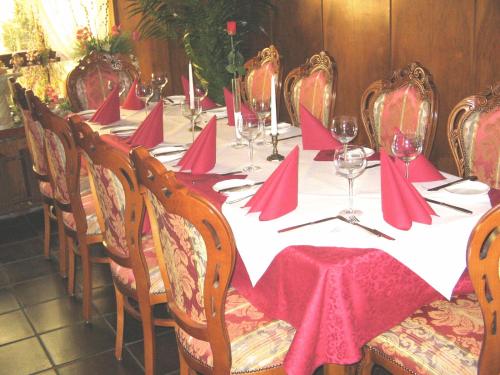 een lange tafel met rode servetten en wijnglazen bij Hotel zum Lamm in Gundelsheim