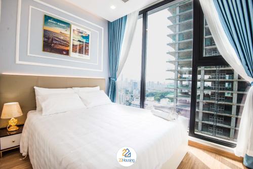a bedroom with a white bed and a large window at Vinhomes Metropolis luxury Hotel & Residence in Hanoi