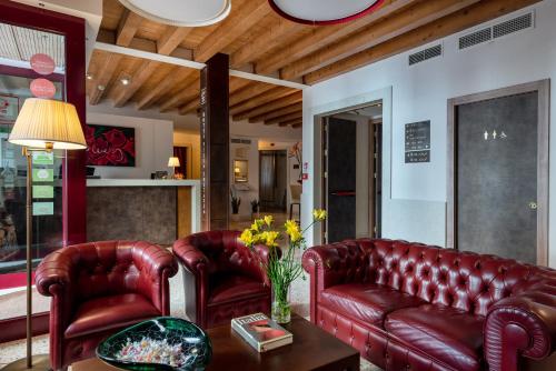 un soggiorno con divani in pelle rossa e tavolo di UNAWAY Ecohotel Villa Costanza Venezia a Mestre