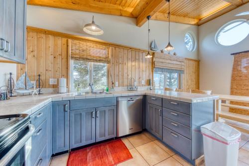 a kitchen with blue cabinets and wooden walls at Grey Haven in Rockaway Beach