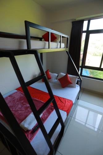 a bedroom with a bunk bed with red and white pillows at Paddyfield Inn in Mananthavady