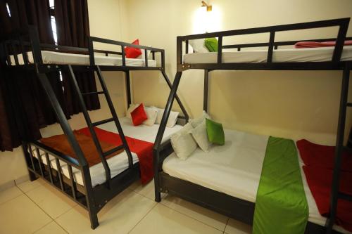 a room with two bunk beds and a bed at Paddyfield Inn in Mananthavady