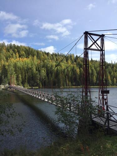 a bridge over a body of water with trees at 4 persoons Stuga in Hammarstrand