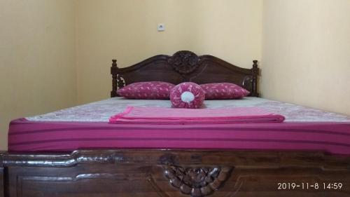 a pink teddy bear sitting on top of a bed at Kumojoyo Homestay in Borobudur