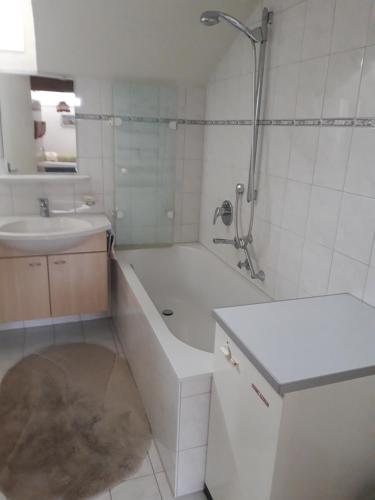 ein Bad mit einer Badewanne, einem Waschbecken und einer Dusche in der Unterkunft Ferienwohnung Buddatsch-Hofmann in Oberstdorf