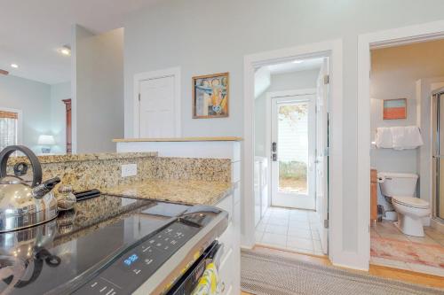 a kitchen with a stove top oven next to a bathroom at The Lemon Drop in Rosemary Beach