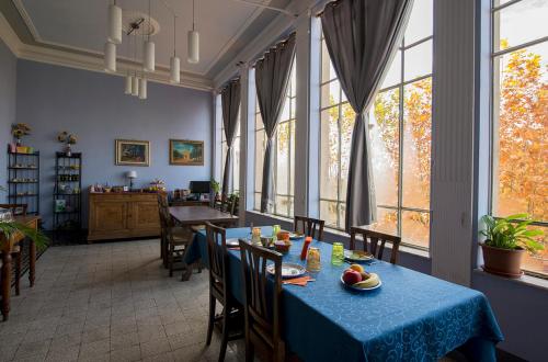 un comedor con una mesa azul y algunas ventanas en Tuscany Experience BnB, en Foiano della Chiana