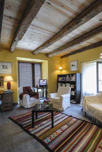 a living room with yellow walls and a wooden ceiling at Gite de la Cascade in Salles-la-Source