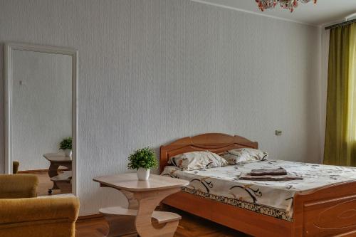 a bedroom with a bed and a table and a chair at Alexandrovskaya street in Zaporozhye
