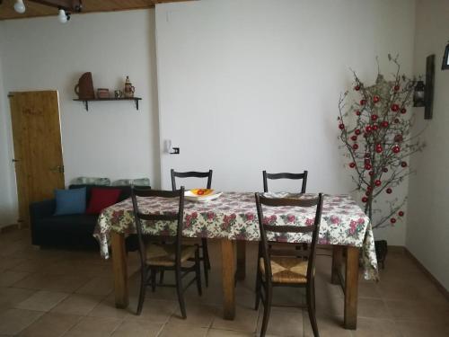 a dining room with a table and four chairs at Etna, salvia e rosmarino in Maletto