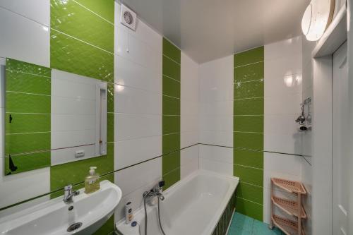a green and white bathroom with a tub and a sink at Alexandrovskaya street in Zaporozhye