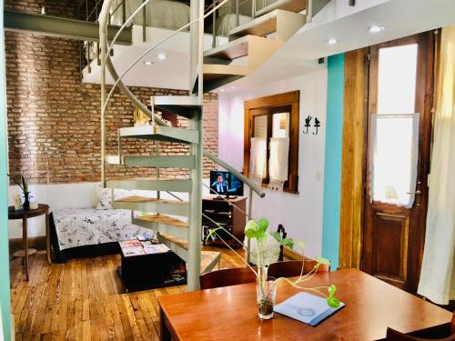 a living room with a spiral staircase and a table at La Casona del Alma in Buenos Aires