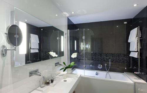 a bathroom with a white tub and a sink and a bath tub at Isola di Albarella Golf Hotel in Isola Albarella