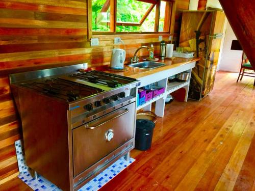 cocina con fogones y fregadero en Cabañas Tunkelen en Punta Indio