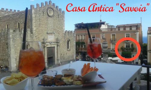 une assiette de nourriture sur une table avec deux verres dans l'établissement Casa Antica Savoia, à Taormine