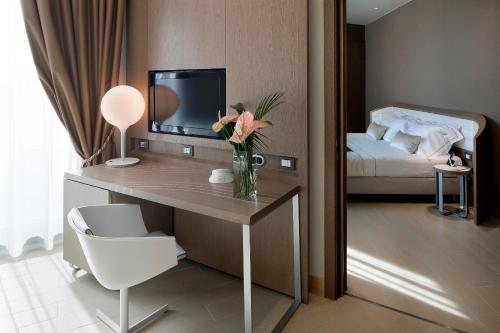 a room with a desk with a vase of flowers on it at Isola di Albarella Golf Hotel in Isola Albarella