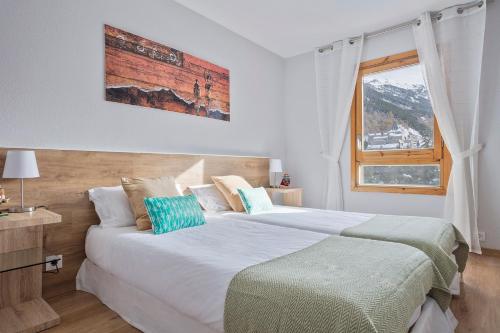 1 dormitorio con 2 camas y ventana en Acogedor Apartamento Baqueira 1500, en Baqueira Beret