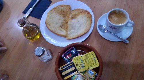 een tafel met een bord brood en een kopje koffie bij La Barbacana in Tramacastiel