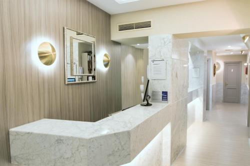 - un hall avec un comptoir en marbre et un miroir dans l'établissement Hospedium Hotel Los Condes, à Madrid