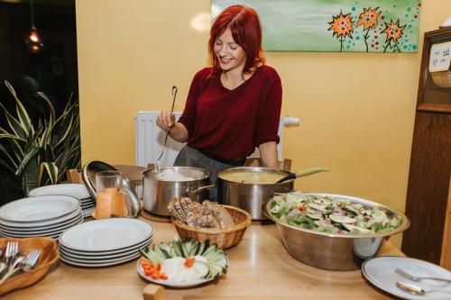 a woman standing in a kitchen preparing food at Vienna Hostel Ruthensteiner in Vienna