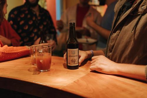 a person sitting at a table with a bottle and a glass at Vienna Hostel Ruthensteiner in Vienna